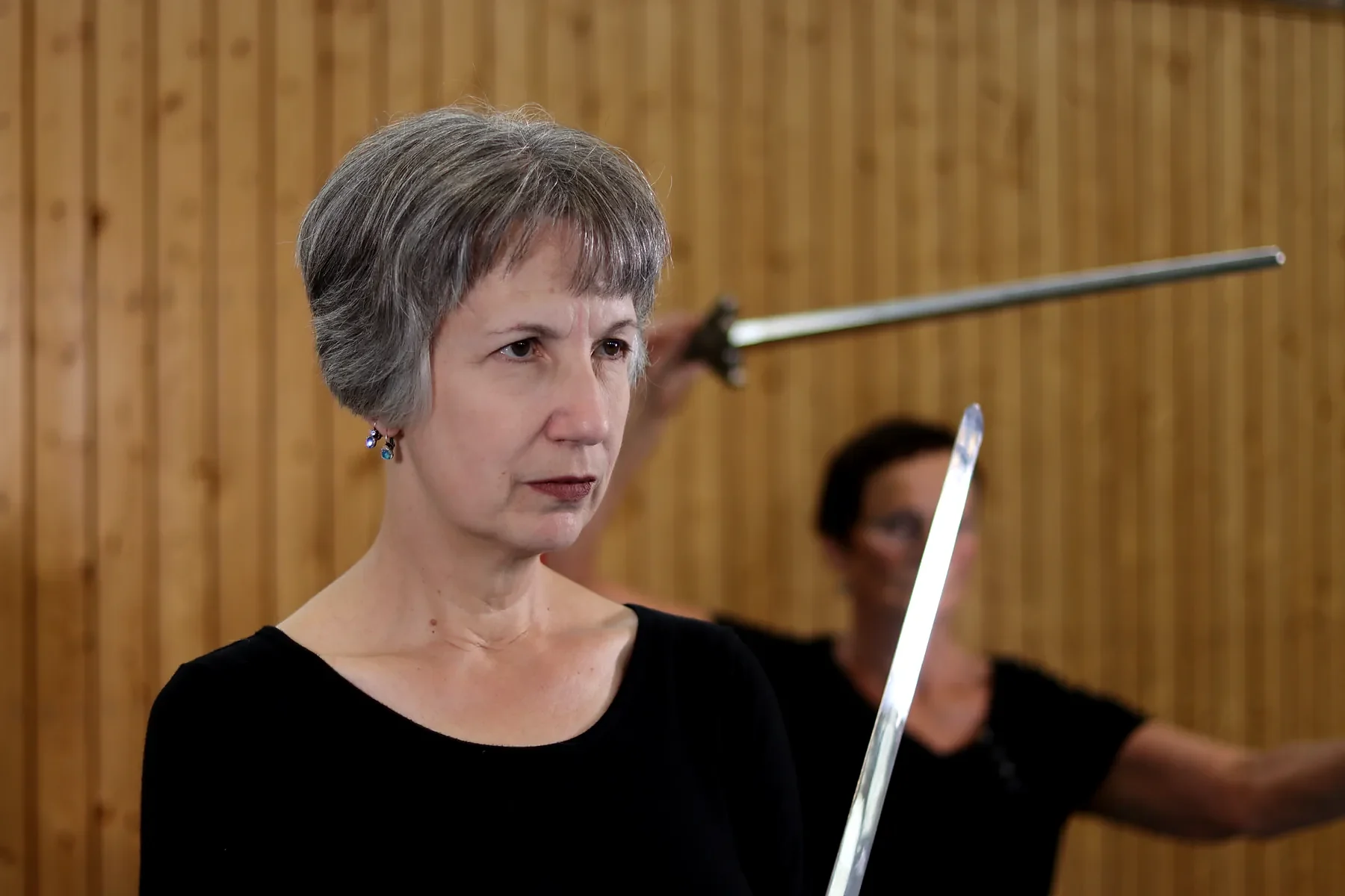 Teilnehmerin fuehrt im Tai Chi eine Form mit dem Schwert aus