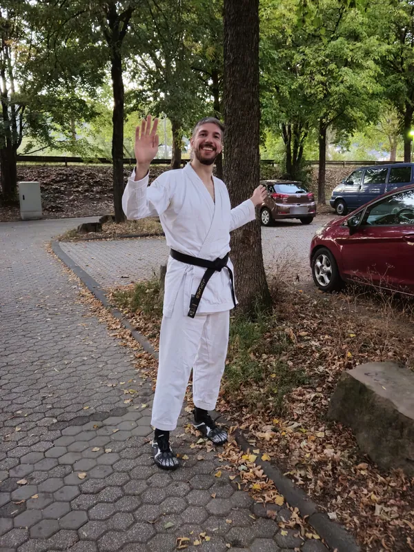 Trainer im Karate-Anzug winkt auf dem Parkplatz an der Speestraße